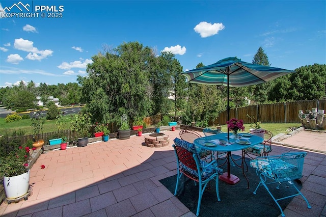 view of patio with outdoor dining space, an outdoor fire pit, and a fenced backyard