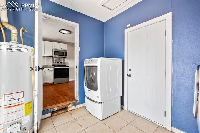 laundry room with water heater, laundry area, washer / clothes dryer, and light tile patterned floors