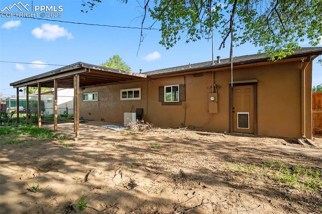 rear view of property with a patio area and stucco siding