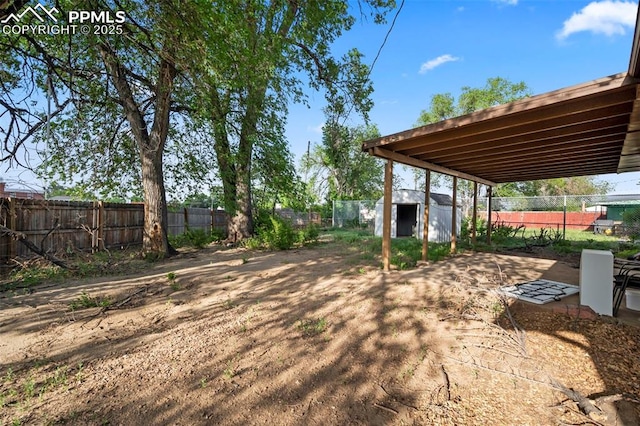 view of yard with an outbuilding, a fenced backyard, and a shed