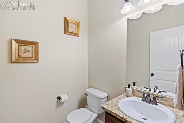 half bathroom with toilet and vanity