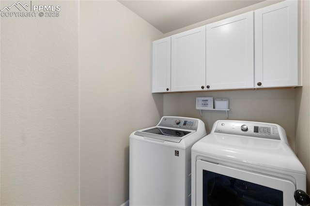 clothes washing area featuring washer and clothes dryer and cabinet space