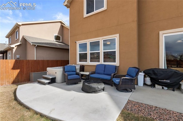 view of patio featuring a grill, fence, a hot tub, and an outdoor hangout area