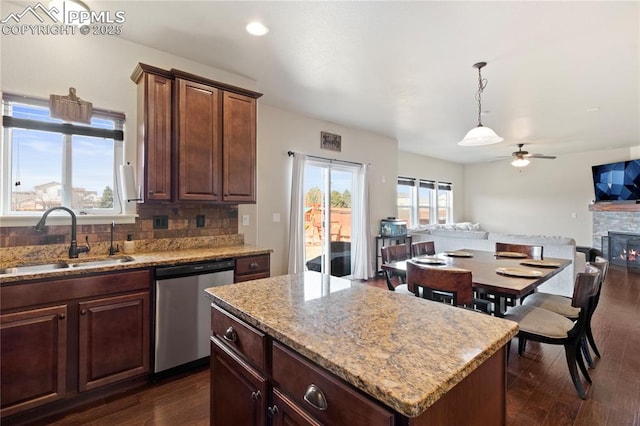 kitchen featuring a wealth of natural light, open floor plan, a sink, and stainless steel dishwasher