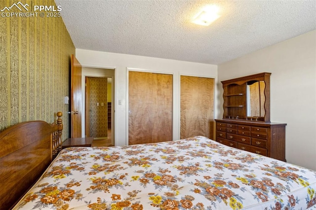 bedroom featuring a textured ceiling and two closets