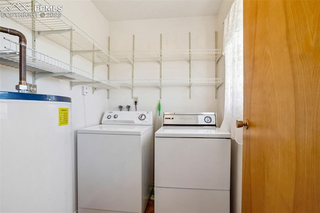 laundry room with laundry area, water heater, and independent washer and dryer