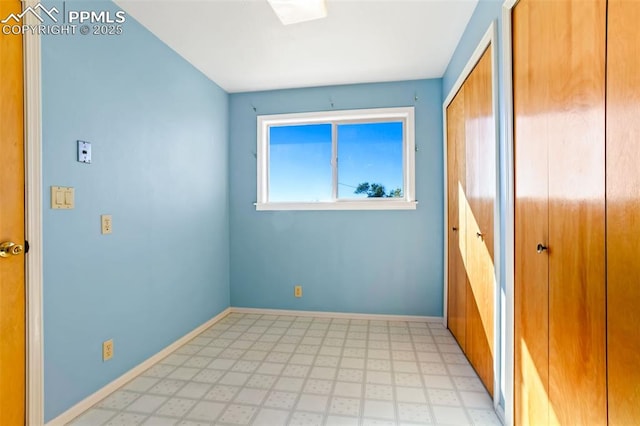 unfurnished bedroom featuring light floors and baseboards