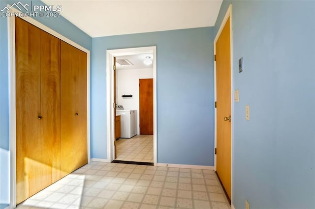 unfurnished bedroom featuring light floors, a closet, washing machine and dryer, and baseboards