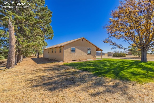 view of property exterior featuring a yard and stucco siding