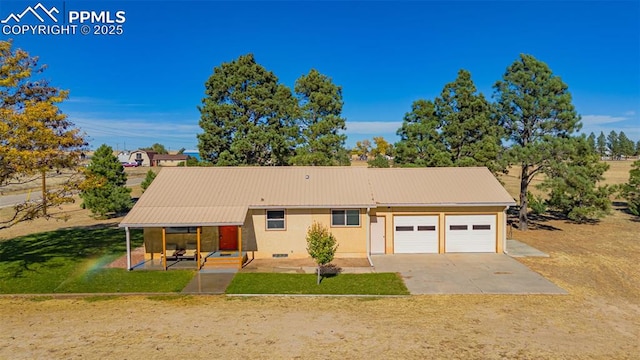 single story home featuring stucco siding, concrete driveway, an attached garage, metal roof, and a front lawn