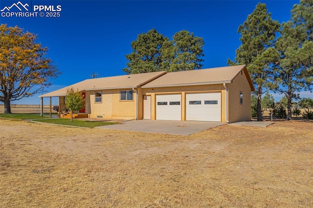 ranch-style house with concrete driveway, metal roof, an attached garage, and stucco siding