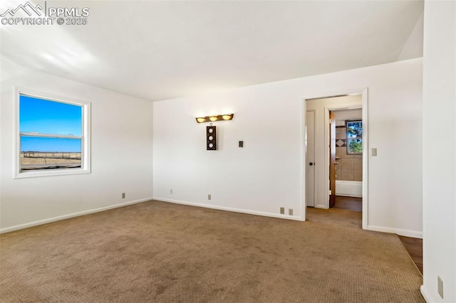 carpeted spare room with baseboards