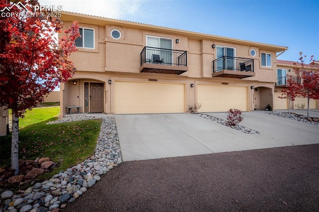 view of front of home featuring a garage, concrete driveway, and stucco siding