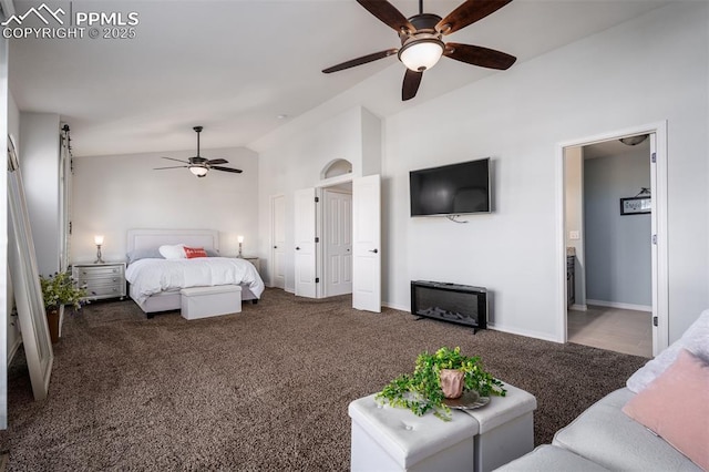 carpeted bedroom with a ceiling fan, lofted ceiling, baseboards, and ensuite bath