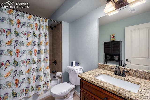 bathroom featuring visible vents, a textured wall, toilet, shower / tub combo with curtain, and vanity