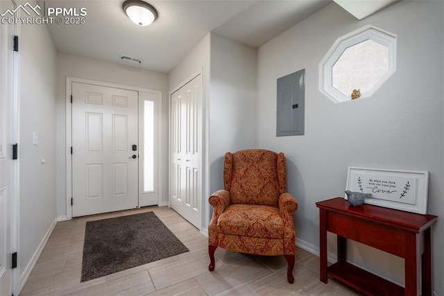 foyer featuring plenty of natural light, baseboards, electric panel, and visible vents