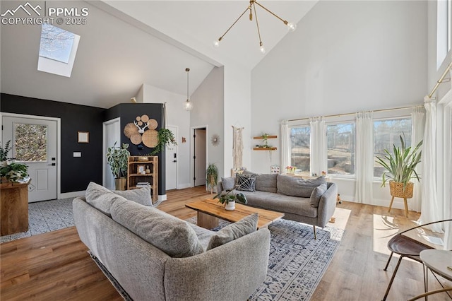 living area with a skylight, high vaulted ceiling, and wood finished floors