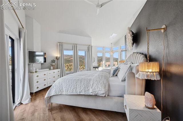 bedroom featuring high vaulted ceiling and wood finished floors