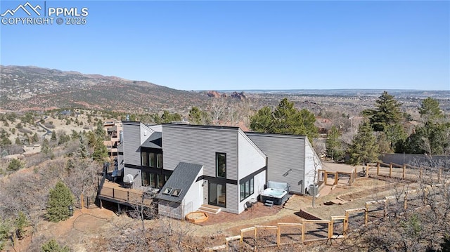 exterior space with entry steps, a mountain view, and fence