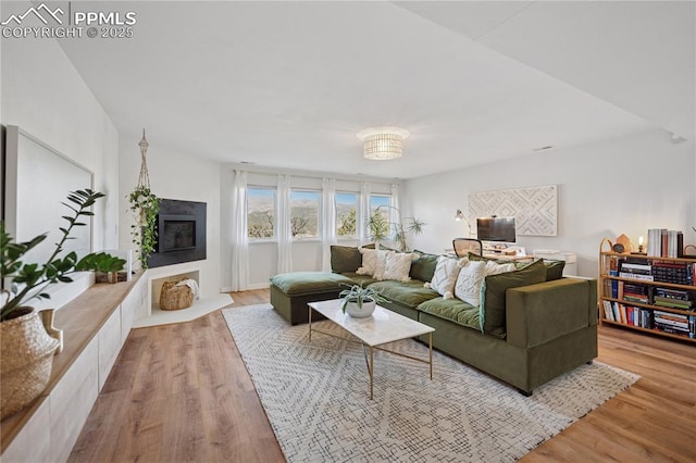 living area with a fireplace with flush hearth and wood finished floors