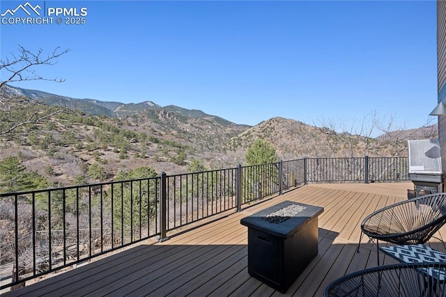 wooden terrace with a mountain view and a fire pit