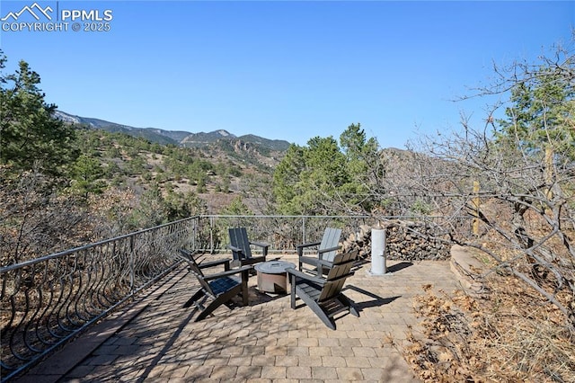 view of patio with a fire pit and a mountain view