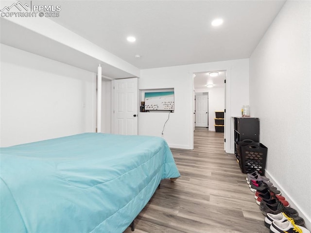 bedroom with baseboards, wood finished floors, and recessed lighting