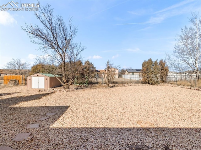 view of yard featuring a fenced backyard, an outdoor structure, and a storage shed