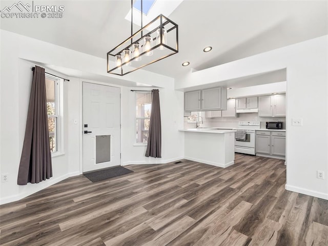 kitchen featuring dark wood-style flooring, white range with electric cooktop, gray cabinets, light countertops, and black microwave