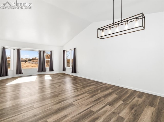 unfurnished living room featuring baseboards, vaulted ceiling, and dark wood-type flooring