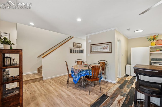 dining area featuring stairs, ornamental molding, wood finished floors, and baseboards