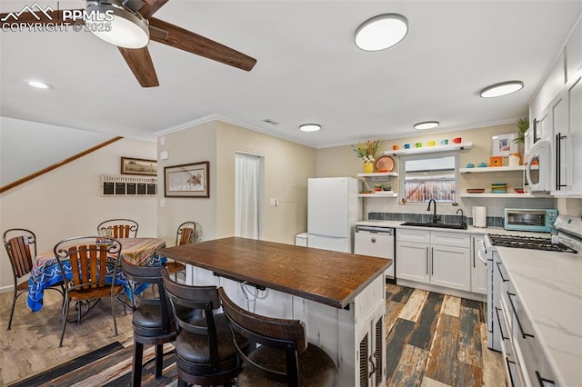 kitchen with white appliances, dark wood-style floors, crown molding, open shelves, and a sink