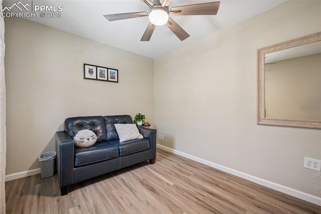 living room featuring a ceiling fan, baseboards, and wood finished floors