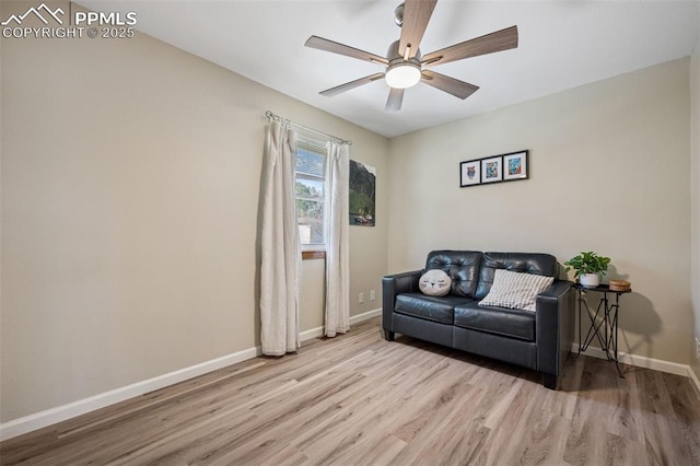 sitting room with wood finished floors, a ceiling fan, and baseboards