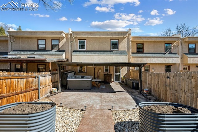 rear view of house featuring a patio area, a fenced backyard, and stucco siding