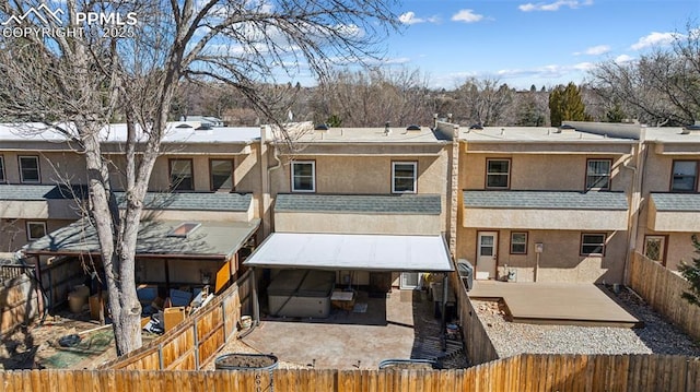 back of house featuring a residential view, a patio area, a fenced backyard, and stucco siding