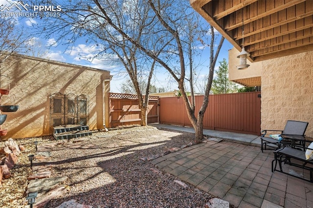 view of patio featuring fence and a gate