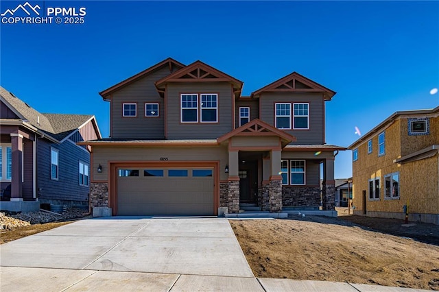 craftsman inspired home with stone siding, driveway, and an attached garage