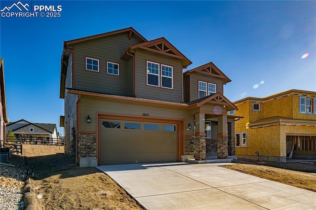 craftsman-style house featuring stone siding, an attached garage, concrete driveway, and fence