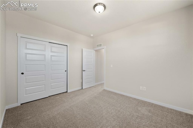 unfurnished bedroom featuring carpet floors, a closet, visible vents, and baseboards