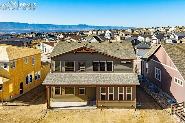 back of property with a residential view and roof with shingles