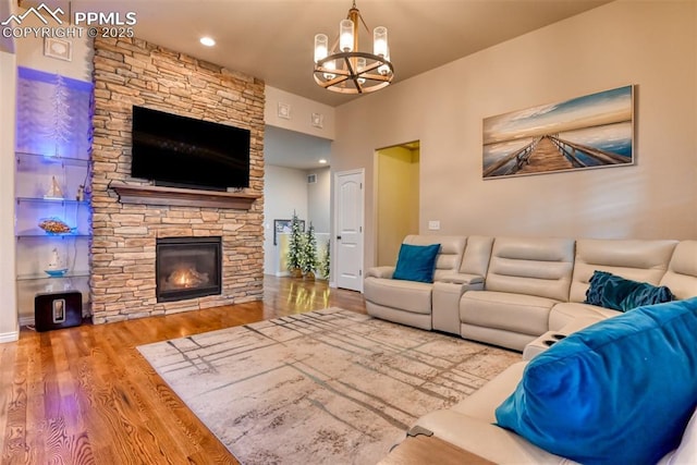 living room featuring a notable chandelier, a fireplace, and wood finished floors