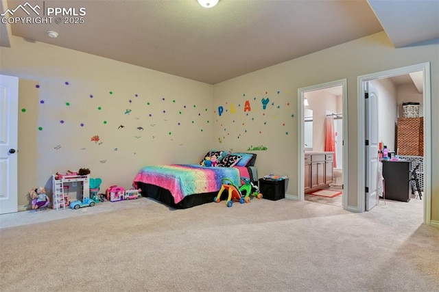 carpeted bedroom with connected bathroom and baseboards