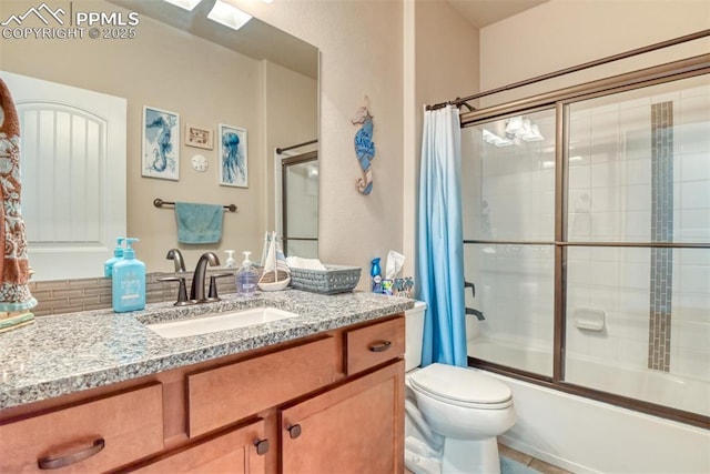 full bathroom featuring combined bath / shower with glass door, vanity, and toilet