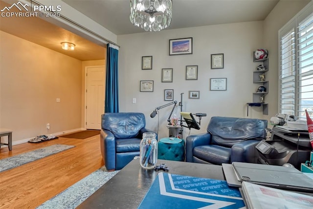 interior space with a notable chandelier, plenty of natural light, baseboards, and wood finished floors