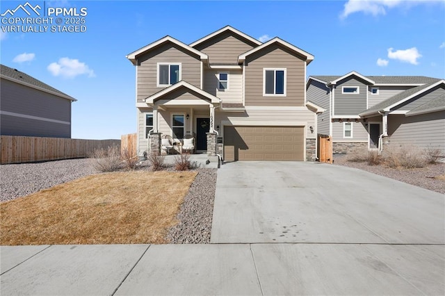 craftsman house featuring stone siding, concrete driveway, fence, and an attached garage