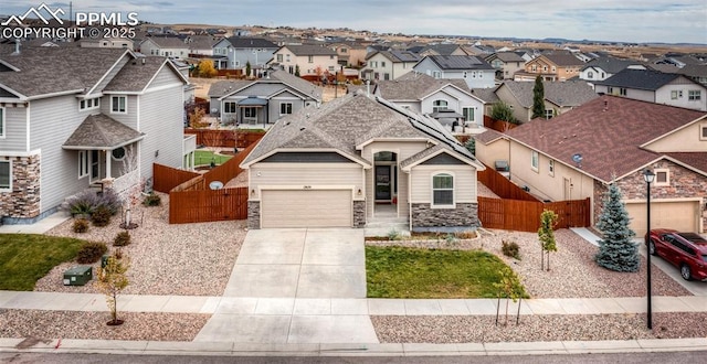 view of front of property with fence, a garage, a residential view, stone siding, and driveway