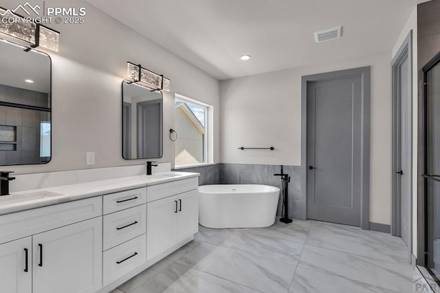 full bathroom featuring a sink, visible vents, a freestanding bath, marble finish floor, and double vanity