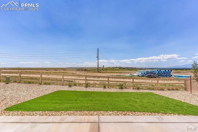 view of yard with a rural view and fence