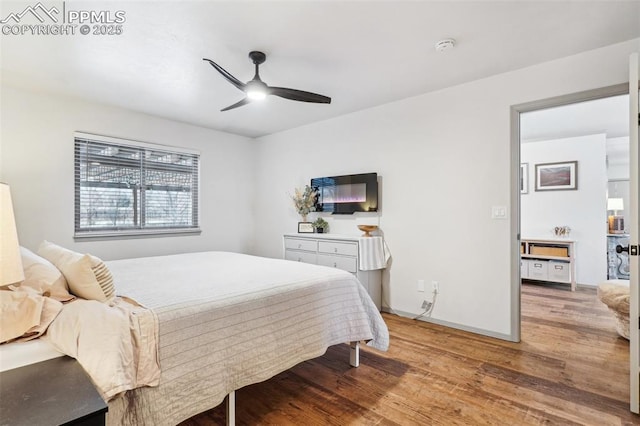 bedroom with ceiling fan, wood finished floors, and baseboards